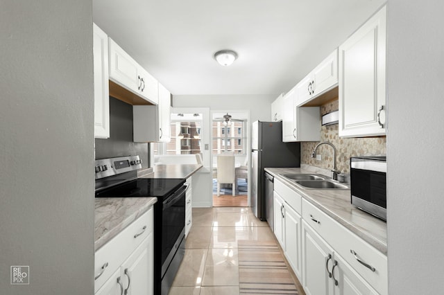 6301 N Sheridan Rd Unit 19O, Chicago, IL 60660 - kitchen with stainless steel appliances, a sink, decorative backsplash, and white cabinets