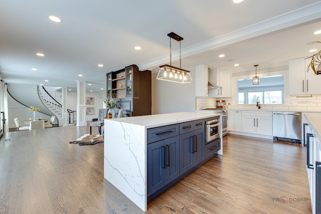 kitchen featuring appliances with stainless steel finishes, white cabinetry, decorative backsplash, light stone countertops, and recessed lighting