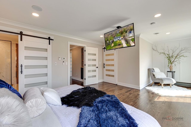 bedroom with a barn door, crown molding, wood finished floors, recessed lighting, and baseboards