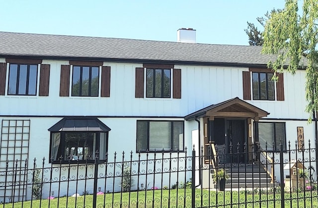 view of front of property featuring a chimney and a shingled roof