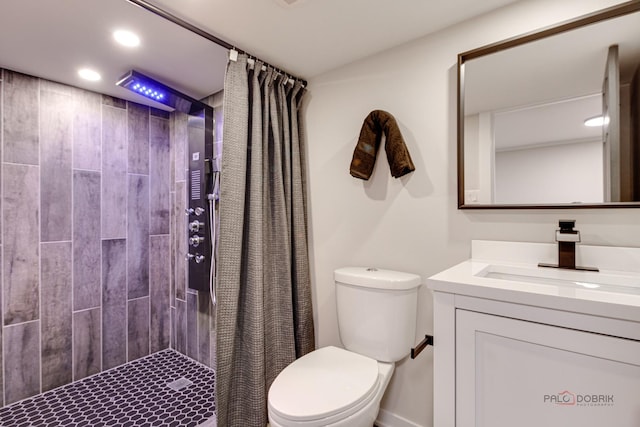 full bathroom featuring toilet, a tile shower, vanity, and recessed lighting