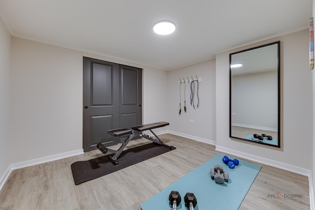 exercise area with wood finished floors and baseboards