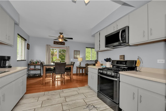 16560 Willow Walk Dr, Lockport, IL 60441 - kitchen with appliances with stainless steel finishes, a ceiling fan, light countertops, white cabinetry, and light wood-style floors