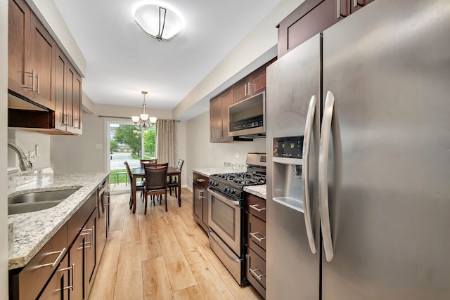 8530 Westberry Ln, Tinley Park, IL 60487 - kitchen with stainless steel appliances, a sink, a chandelier, light wood finished floors, and light stone counters
