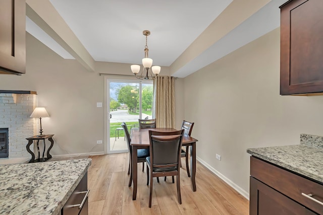 8530 Westberry Ln, Tinley Park, IL 60487 - dining area featuring light wood-type flooring, a chandelier, baseboards, and a brick fireplace