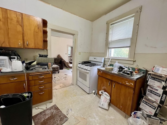 866 E Center St, Paxton, IL 60957 - kitchen featuring gas range gas stove, brown cabinetry, and dark countertops