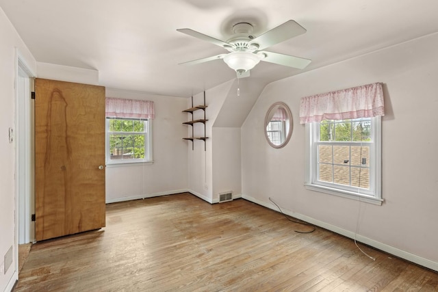 additional living space featuring wood finished floors, ceiling fan, baseboards, and lofted ceiling