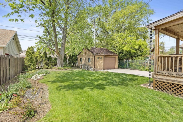 view of yard featuring an outbuilding, a garage, and driveway
