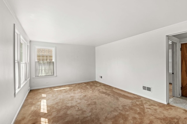 spare room with carpet floors, baseboards, and ornamental molding