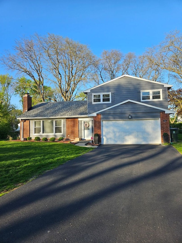 8 W Emerson St, Arlington Heights, IL 60005 - tri-level home with asphalt driveway, brick siding, a chimney, a front yard, and a garage
