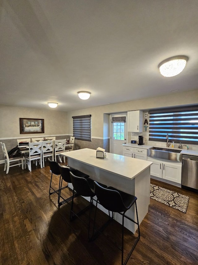 8 W Emerson St, Arlington Heights, IL 60005 - kitchen with a sink, stainless steel dishwasher, a breakfast bar area, white cabinetry, and dark wood-style floors