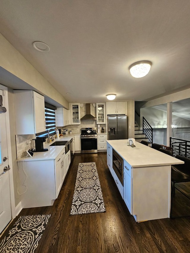 8 W Emerson St, Arlington Heights, IL 60005 - kitchen with stainless steel appliances, wall chimney range hood, a sink, dark wood-style flooring, and white cabinets