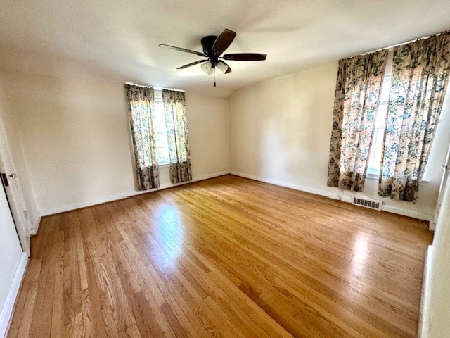 unfurnished room featuring plenty of natural light, wood finished floors, and ceiling fan