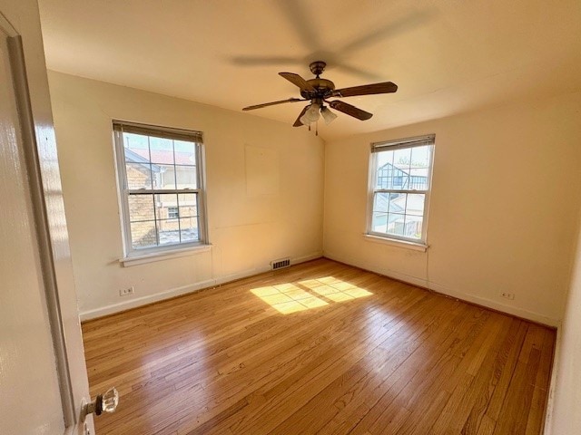 unfurnished room featuring wood finished floors, ceiling fan, and baseboards