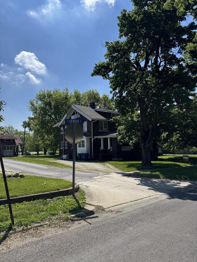 view of front facade featuring a front lawn and curved driveway