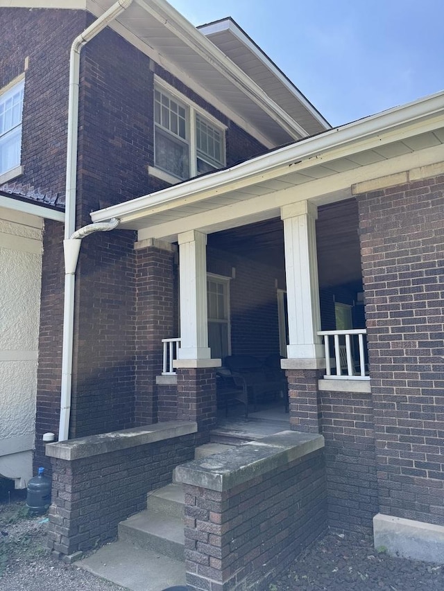 view of side of property with a porch and brick siding