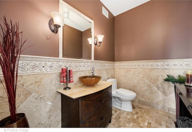 21 E Huron St Unit 3204, Chicago, IL 60611 - half bathroom featuring vanity, a wainscoted wall, toilet, and tile walls