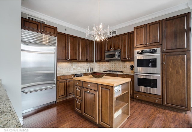 21 E Huron St Unit 3204, Chicago, IL 60611 - kitchen with appliances with stainless steel finishes, butcher block counters, a chandelier, dark wood-style floors, and backsplash