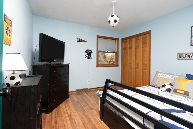 12367 Squirrel Tree Ln, Belvidere, IL 61008 - bedroom with light wood-style flooring, a closet, and baseboards