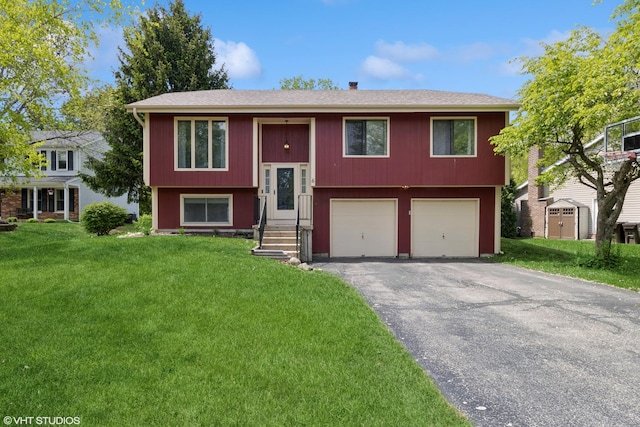 raised ranch featuring driveway, an attached garage, a front lawn, and roof with shingles
