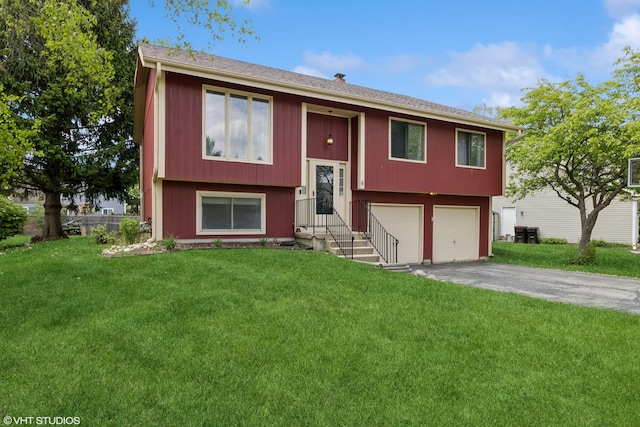 split foyer home featuring driveway, a garage, and a front lawn