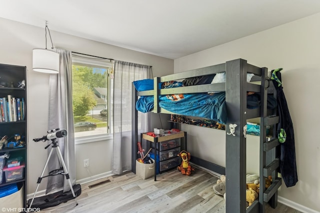 bedroom with wood finished floors and baseboards