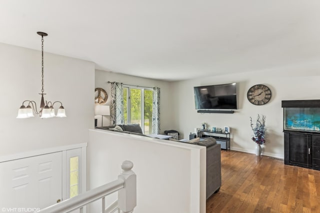 living room with a chandelier, wood finished floors, and baseboards