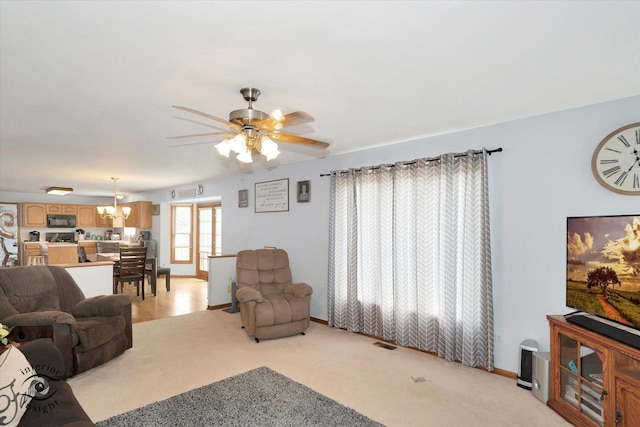 975 S Laura Ln, Coal City, IL 60416 - living room with a ceiling fan, a chandelier, baseboards, and light colored carpet