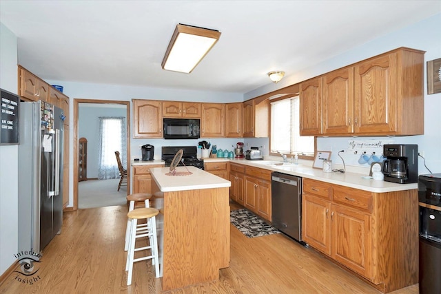 975 S Laura Ln, Coal City, IL 60416 - kitchen featuring black appliances, a kitchen island, light wood-style floors, and a sink