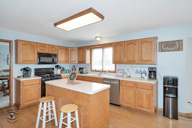 975 S Laura Ln, Coal City, IL 60416 - kitchen featuring black appliances, a sink, light wood-style floors, and a kitchen bar