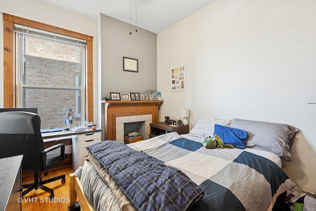 bedroom featuring wood finished floors and an office area