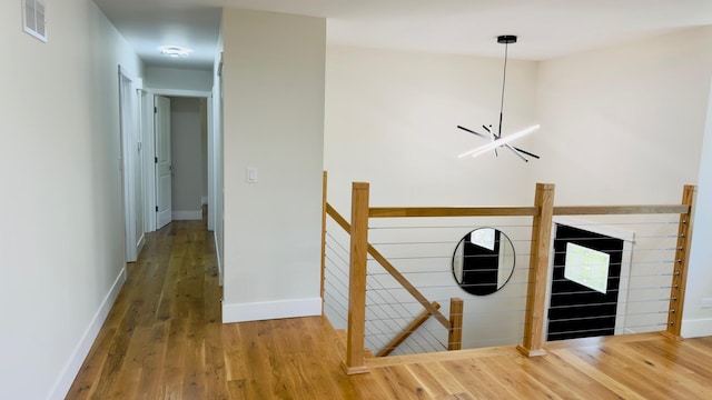 527 Northgate Rd, Lindenhurst, IL 60046 - corridor featuring an upstairs landing, wood finished floors, baseboards, and a chandelier