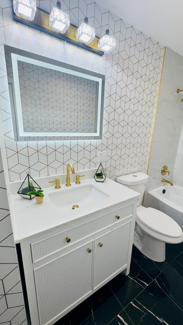 527 Northgate Rd, Lindenhurst, IL 60046 - bathroom with tile walls, vanity, marble finish floors, toilet, and shower / tub combination