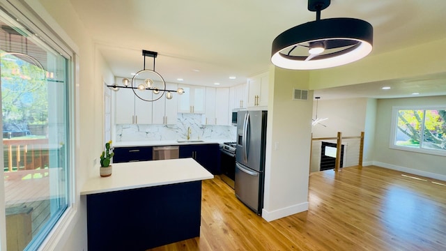 527 Northgate Rd, Lindenhurst, IL 60046 - kitchen featuring appliances with stainless steel finishes, a sink, light wood-type flooring, tasteful backsplash, and light countertops
