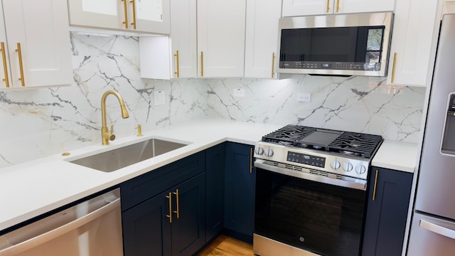 527 Northgate Rd, Lindenhurst, IL 60046 - kitchen featuring appliances with stainless steel finishes, a sink, blue cabinets, light countertops, and white cabinets