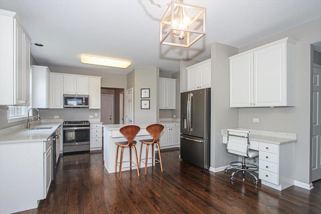 1207 Angle Tarn, West Dundee, IL 60118 - kitchen with appliances with stainless steel finishes, a sink, a kitchen bar, dark wood-style floors, and white cabinets