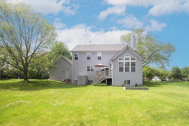 1207 Angle Tarn, West Dundee, IL 60118 - back of property with stairway, a chimney, a wooden deck, and a lawn