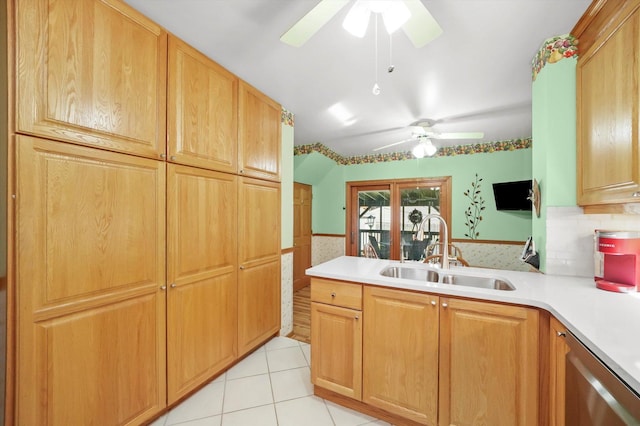 kitchen with ceiling fan, a sink, stainless steel dishwasher, light countertops, and light tile patterned floors