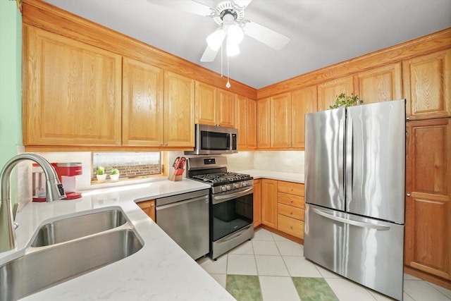 kitchen with stainless steel appliances, a sink, light countertops, and light tile patterned floors