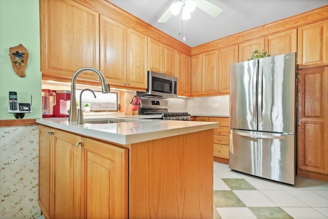 kitchen featuring stainless steel appliances, light brown cabinets, and a ceiling fan