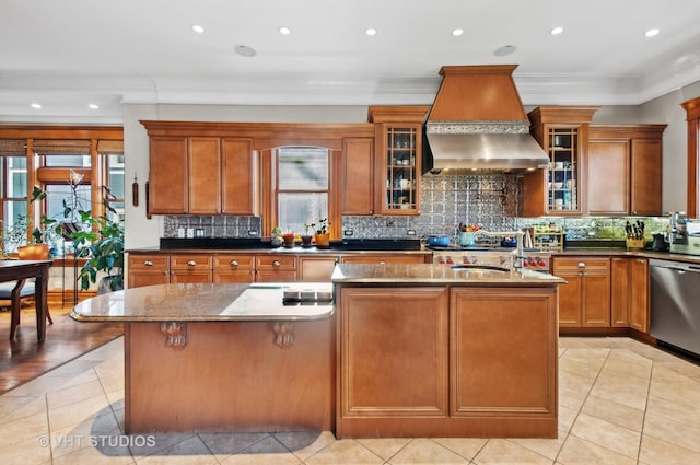 4752 N Beacon St, Chicago, IL 60613 - kitchen with custom exhaust hood, dishwasher, a kitchen island with sink, light tile patterned floors, and brown cabinetry