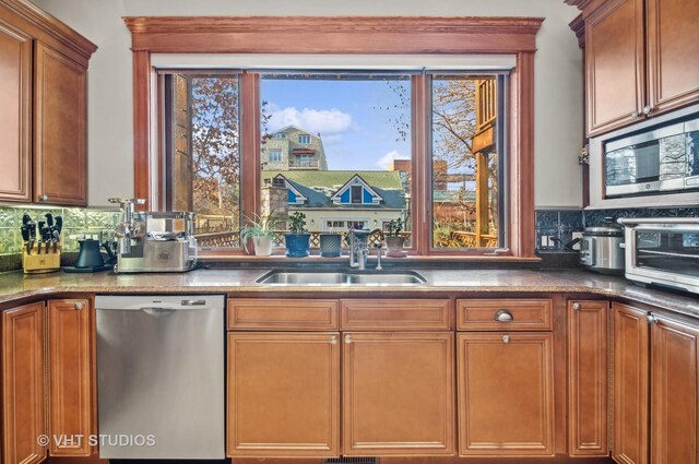 4752 N Beacon St, Chicago, IL 60613 - kitchen with appliances with stainless steel finishes, a sink, tasteful backsplash, and brown cabinetry