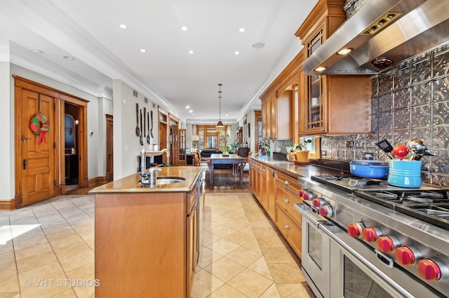 4752 N Beacon St, Chicago, IL 60613 - kitchen featuring wall chimney exhaust hood, double oven range, a sink, light tile patterned flooring, and a center island with sink