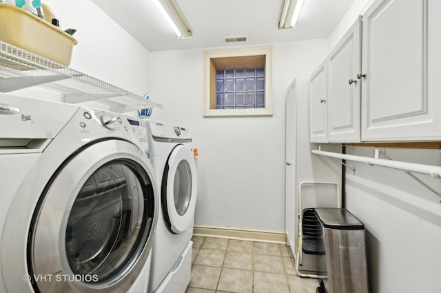 4752 N Beacon St, Chicago, IL 60613 - washroom with cabinet space, washing machine and clothes dryer, baseboards, and light tile patterned flooring