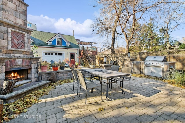 4752 N Beacon St, Chicago, IL 60613 - view of patio featuring outdoor dining space, an outdoor kitchen, area for grilling, fence, and an outdoor stone fireplace