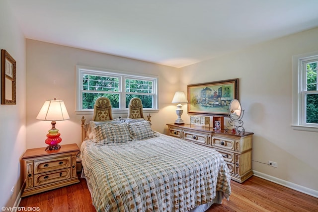 bedroom featuring wood finished floors and baseboards