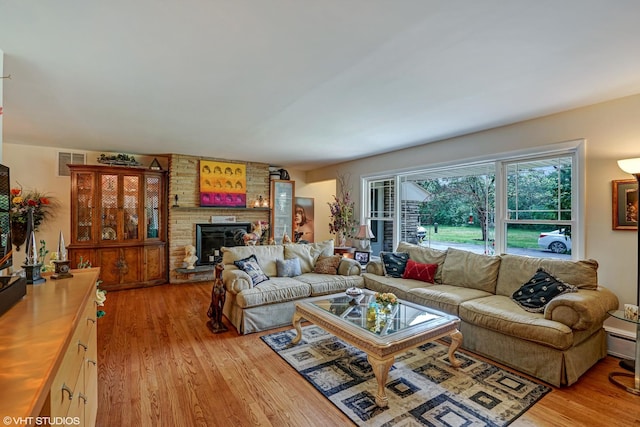 living area featuring light wood finished floors and a large fireplace