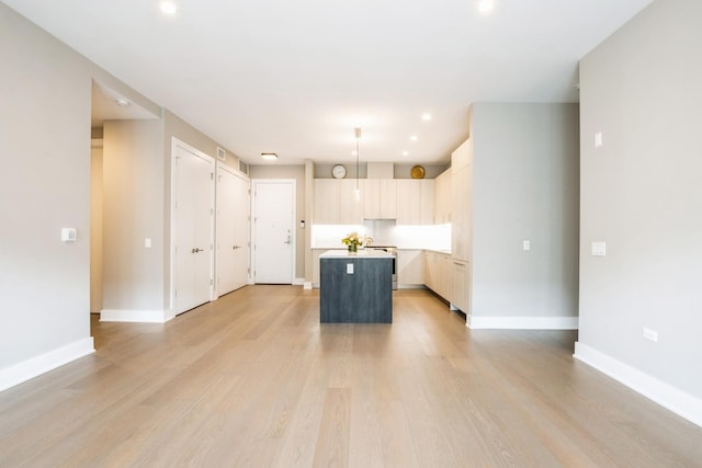 1701 W Webster Ave Unit 611, Chicago, IL 60614 - kitchen with a kitchen island, stove, light wood-style flooring, light countertops, and baseboards