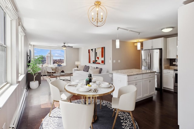 dining room with dark wood-style floors, ceiling fan, a chandelier, and a baseboard heating unit