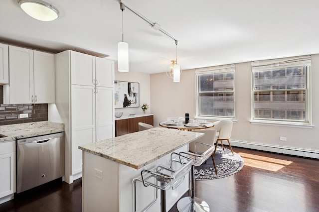 kitchen featuring stainless steel dishwasher, a baseboard heating unit, dark wood-type flooring, white cabinets, and backsplash